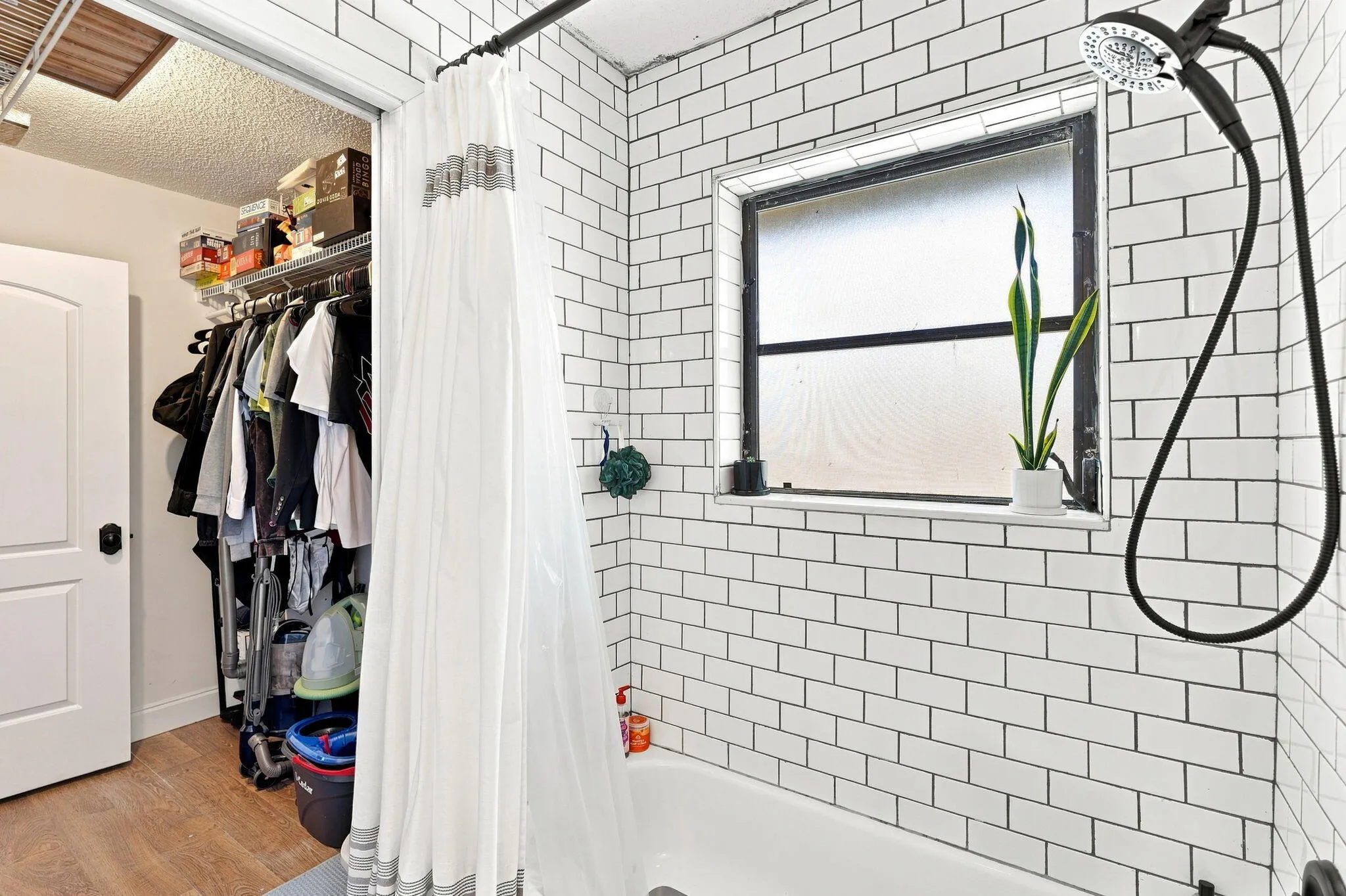 White subway tile surround with dark grout, a built-in bathtub and a window with a sill