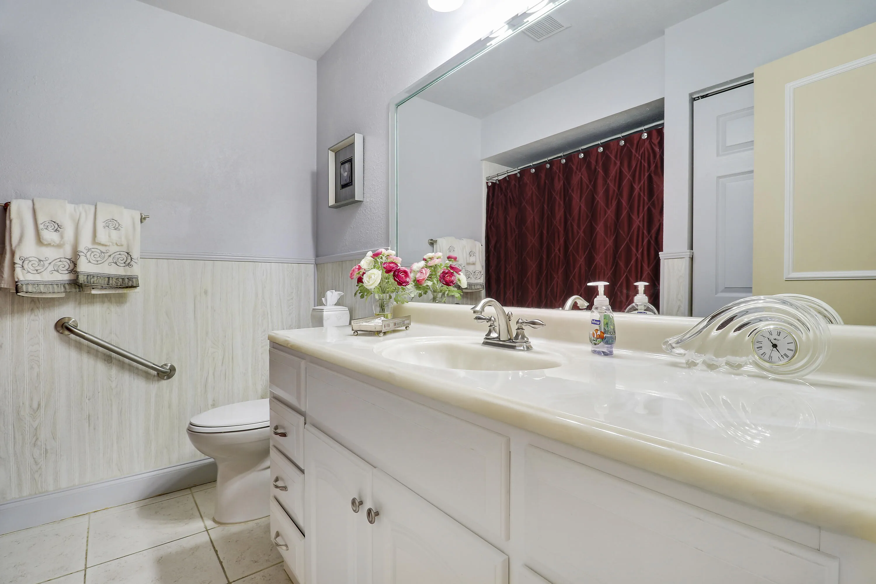 The guest bath is located just outside of the guest bedroom and across from the kitchen.