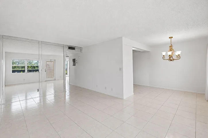 White tile flooring, overhead lighting, and mirrored wall