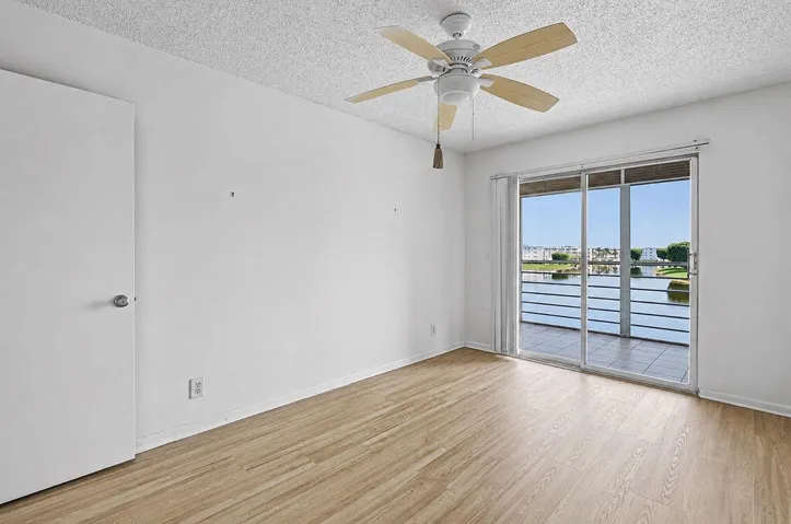 Wood-finish flooring with a ceiling fan and direct access to an exterior balcony