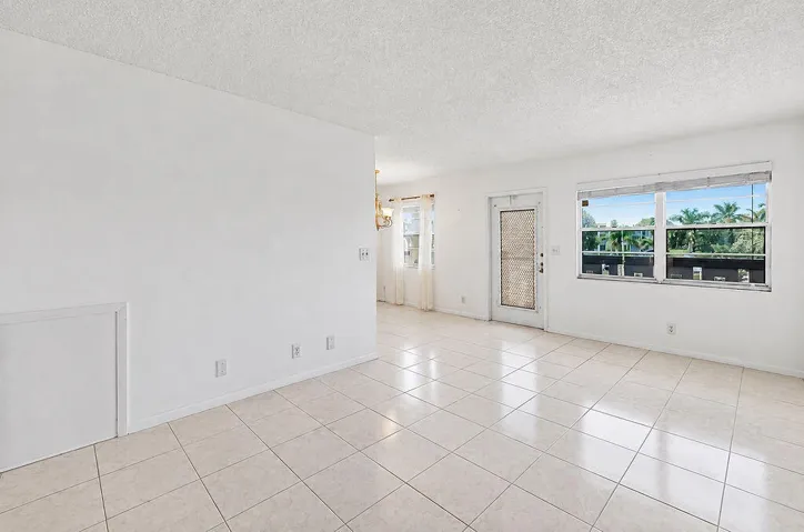 Neutral-toned tile flooring throughout with white walls and a textured ceiling