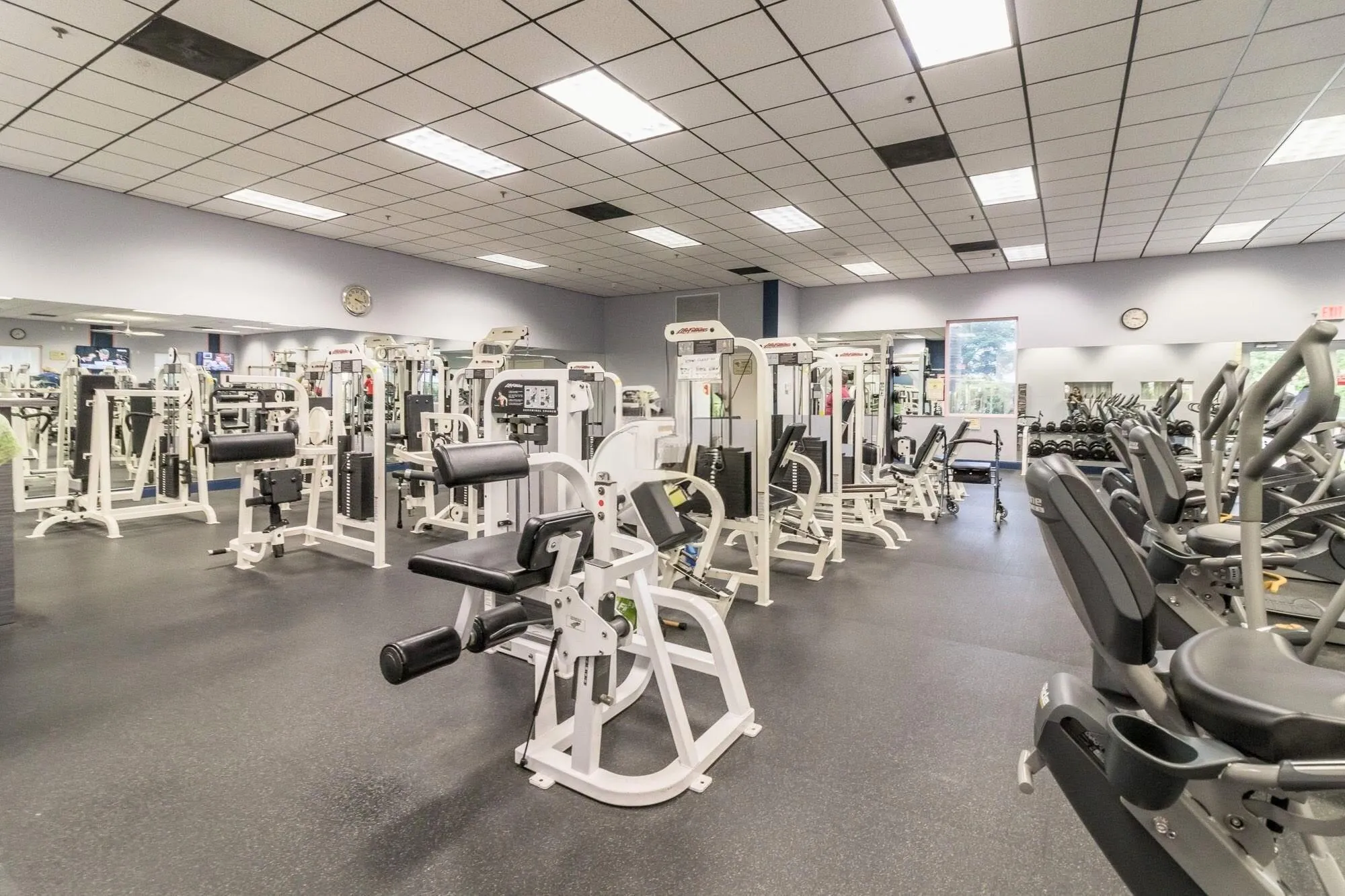 Fitness center with exercise equipment, mirrored walls, and recessed lighting