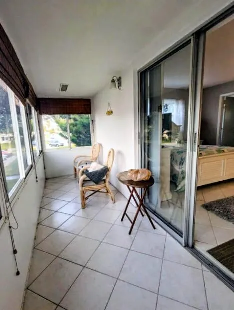 Enclosed balcony featuring large windows, square tile flooring, and a sliding glass door