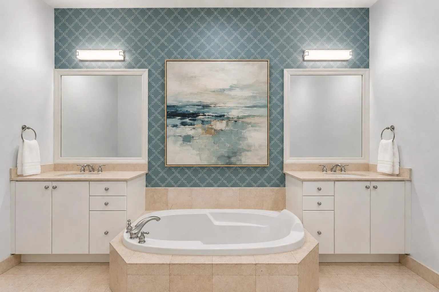 Dual vanity with integrated sinks, built-in soaking tub, patterned accent wall, and tiled flooring