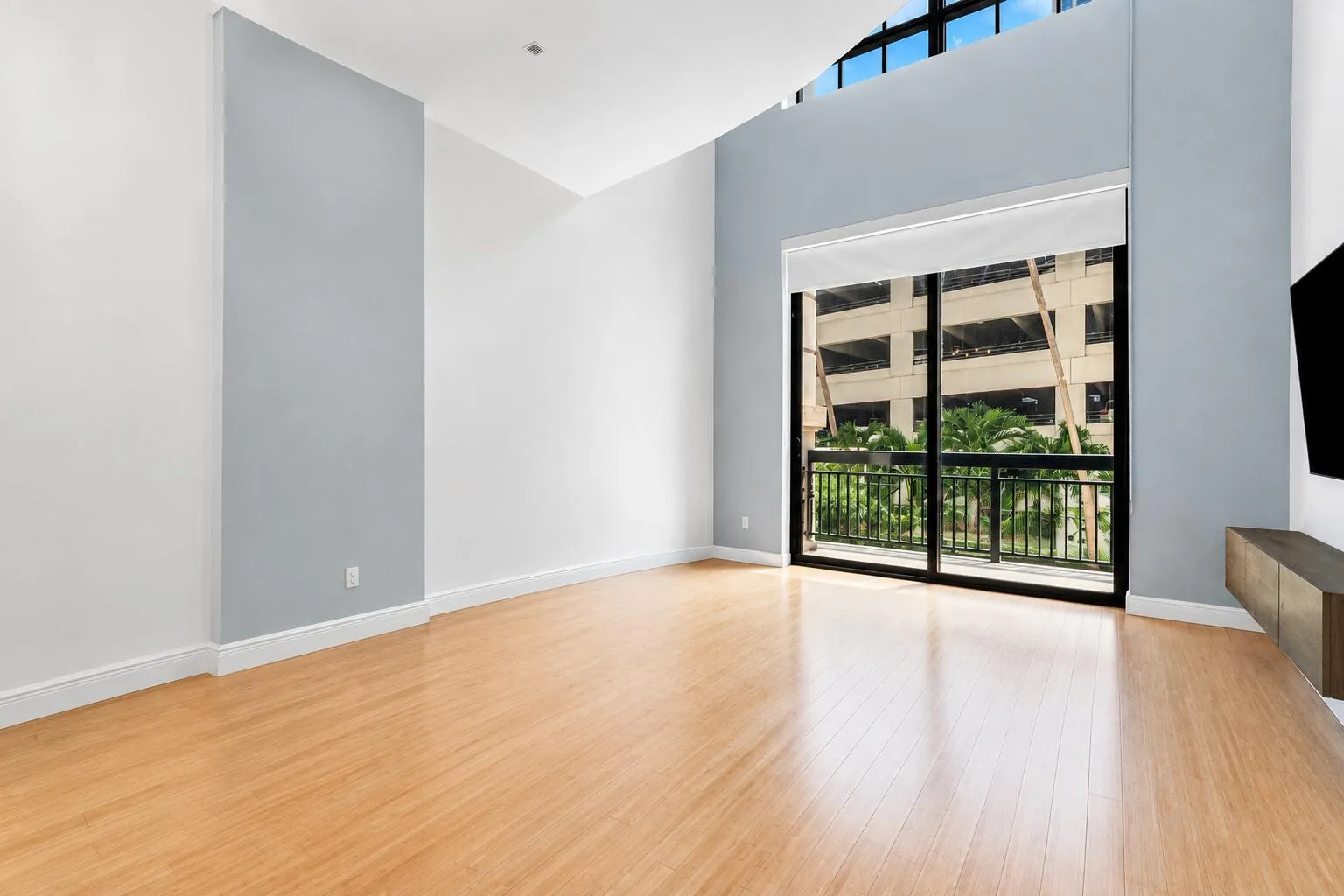 Hardwood flooring, high ceilings, full-height windows, balcony, and a built-in media console