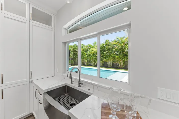Large Apron Sink overlooking sparkling pool and pass through window