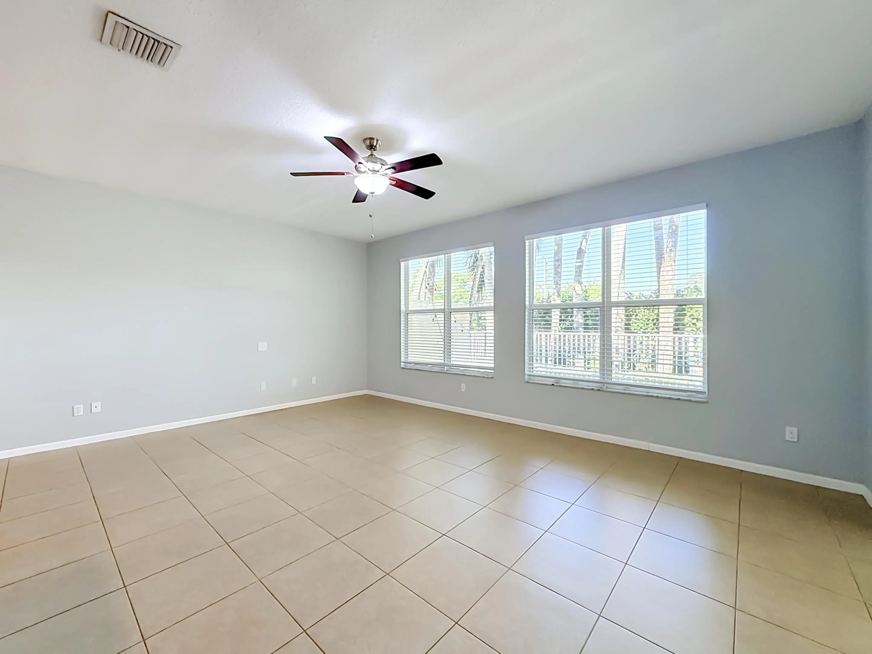 Tile flooring, ceiling fan with integrated lighting, multiple windows with blinds