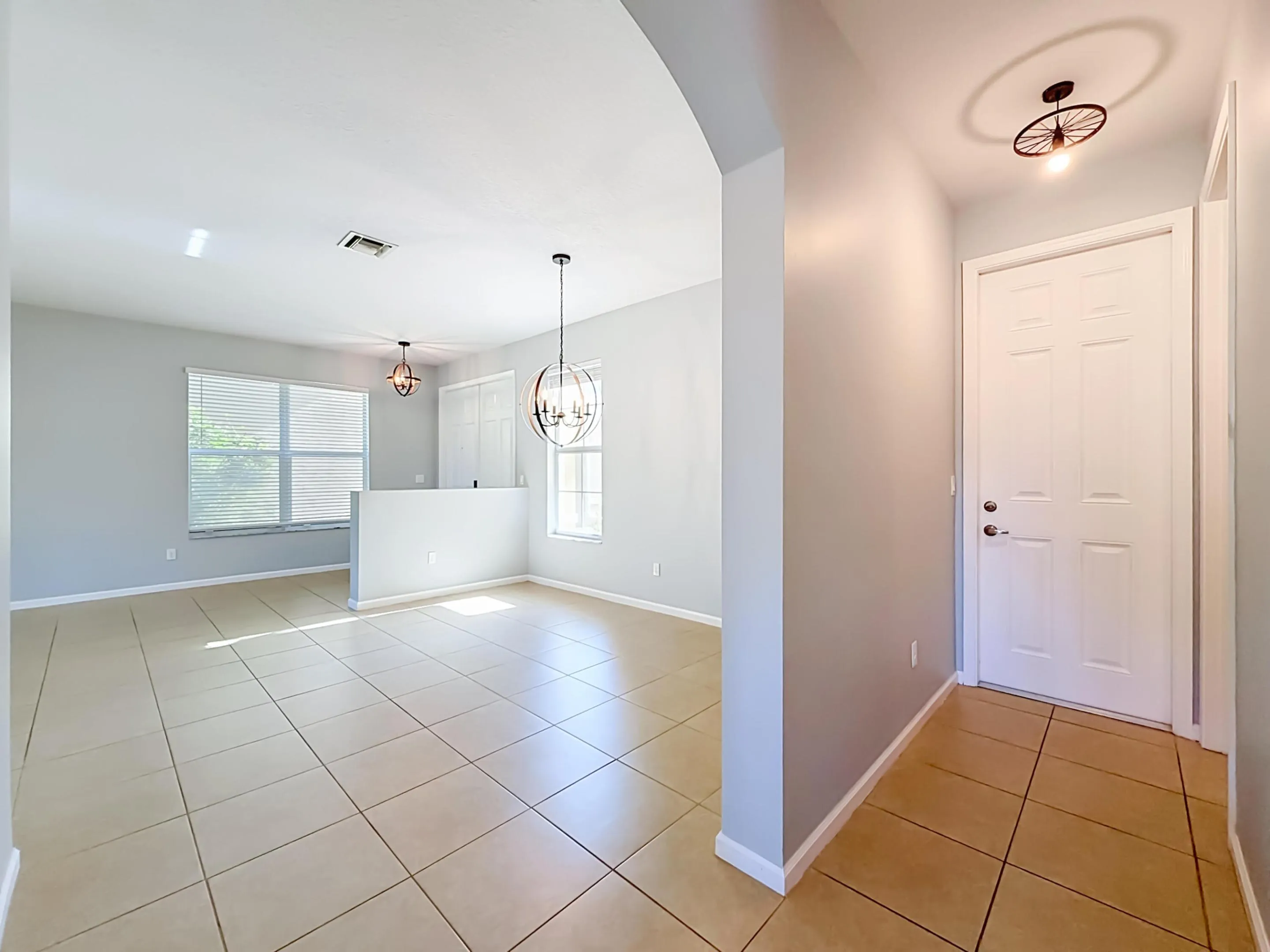 Neutral tone wall paint, tile flooring, arched entryway, contemporary ceiling light fixture, and window blinds