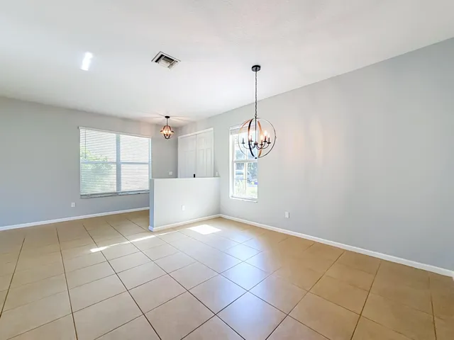 Tiled flooring, dual windows with blinds, recessed lighting, and modern orb-style chandeliers