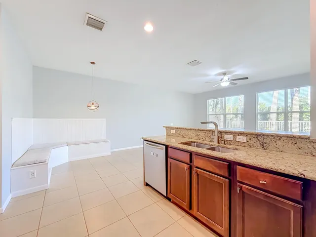 Kitchen featuring wood cabinets, stainless steel sink, granite countertops, and an integrated dishwasher