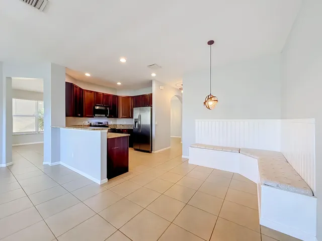Kitchen featuring dark wood cabinetry, stainless steel appliances, and a breakfast bar