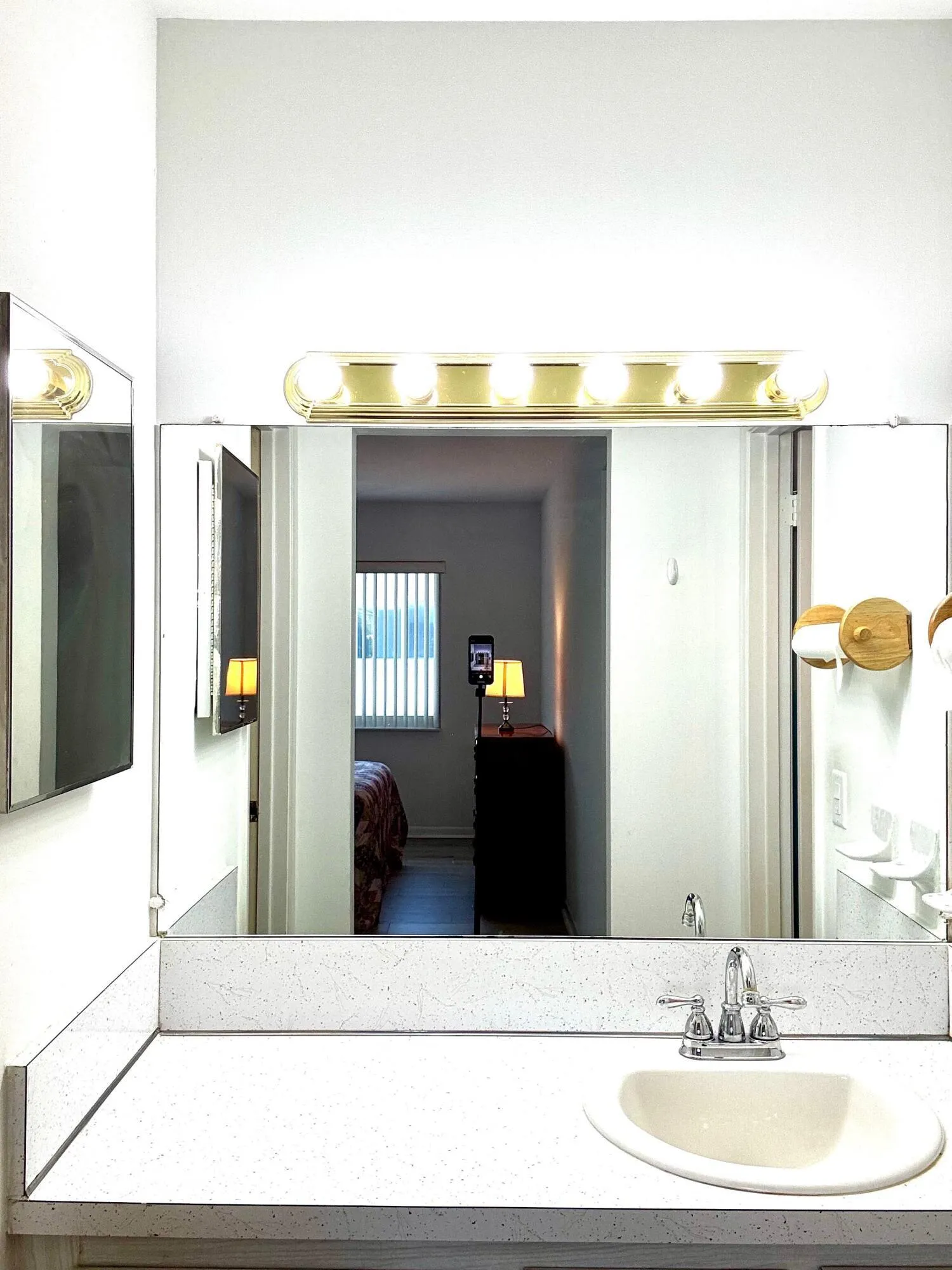 Bathroom vanity with an integrated sink, polished chrome faucet, and expansive wall-mounted mirror