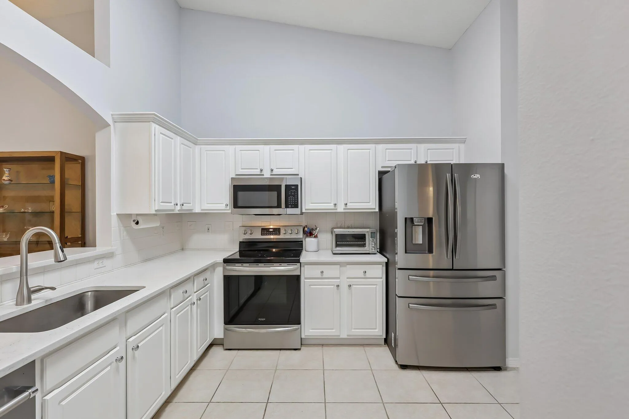 Kitchen featuring white cabinetry, stainless steel appliances, a stainless steel sink, and white countertops