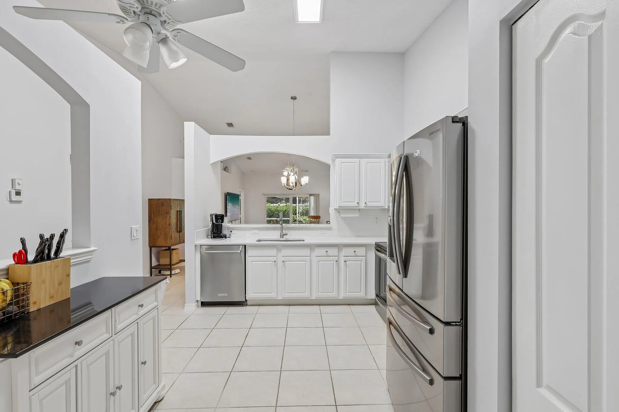 Kitchen featuring white cabinetry, stainless steel appliances, a ceiling fan, and tiled flooring
