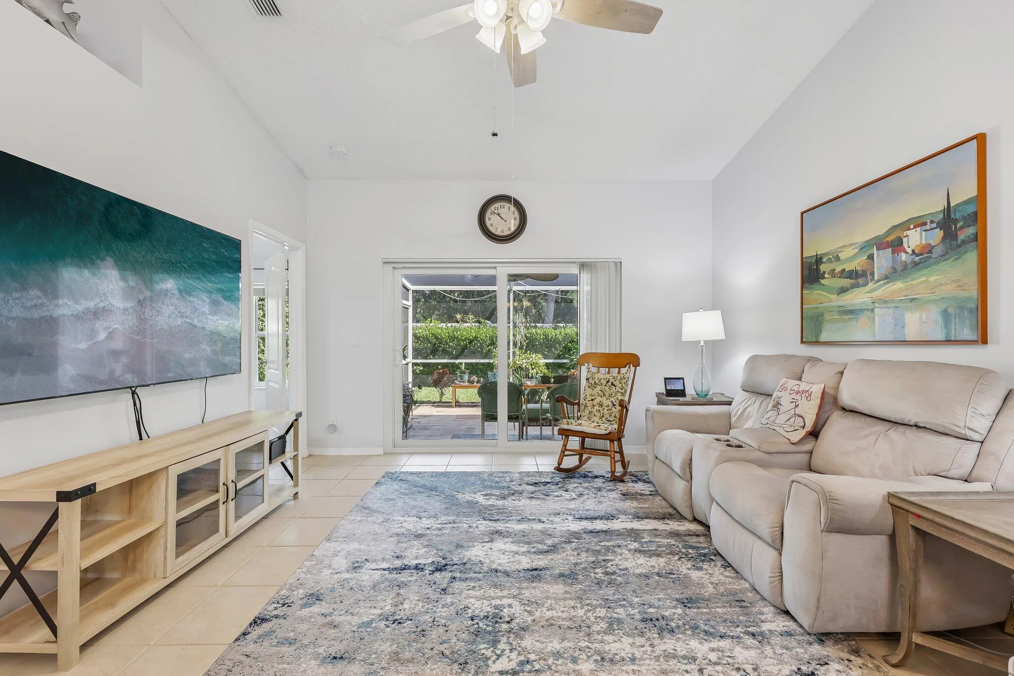Vaulted ceiling, ceramic tile flooring, ceiling fan, and sliding glass door with exterior exposure