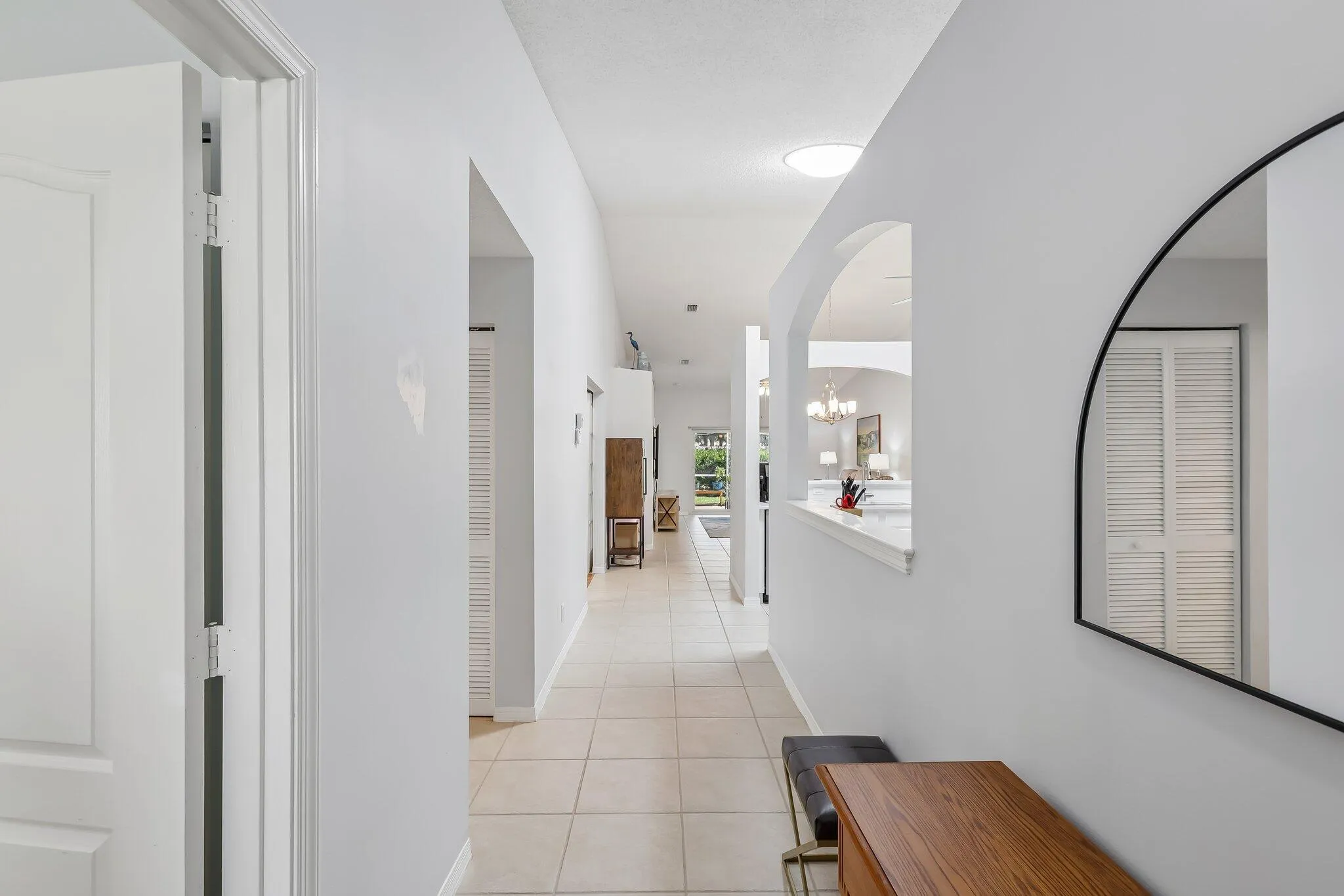 Arched room opening, tiled flooring, vaulted ceiling, recessed lighting, and white interior doors