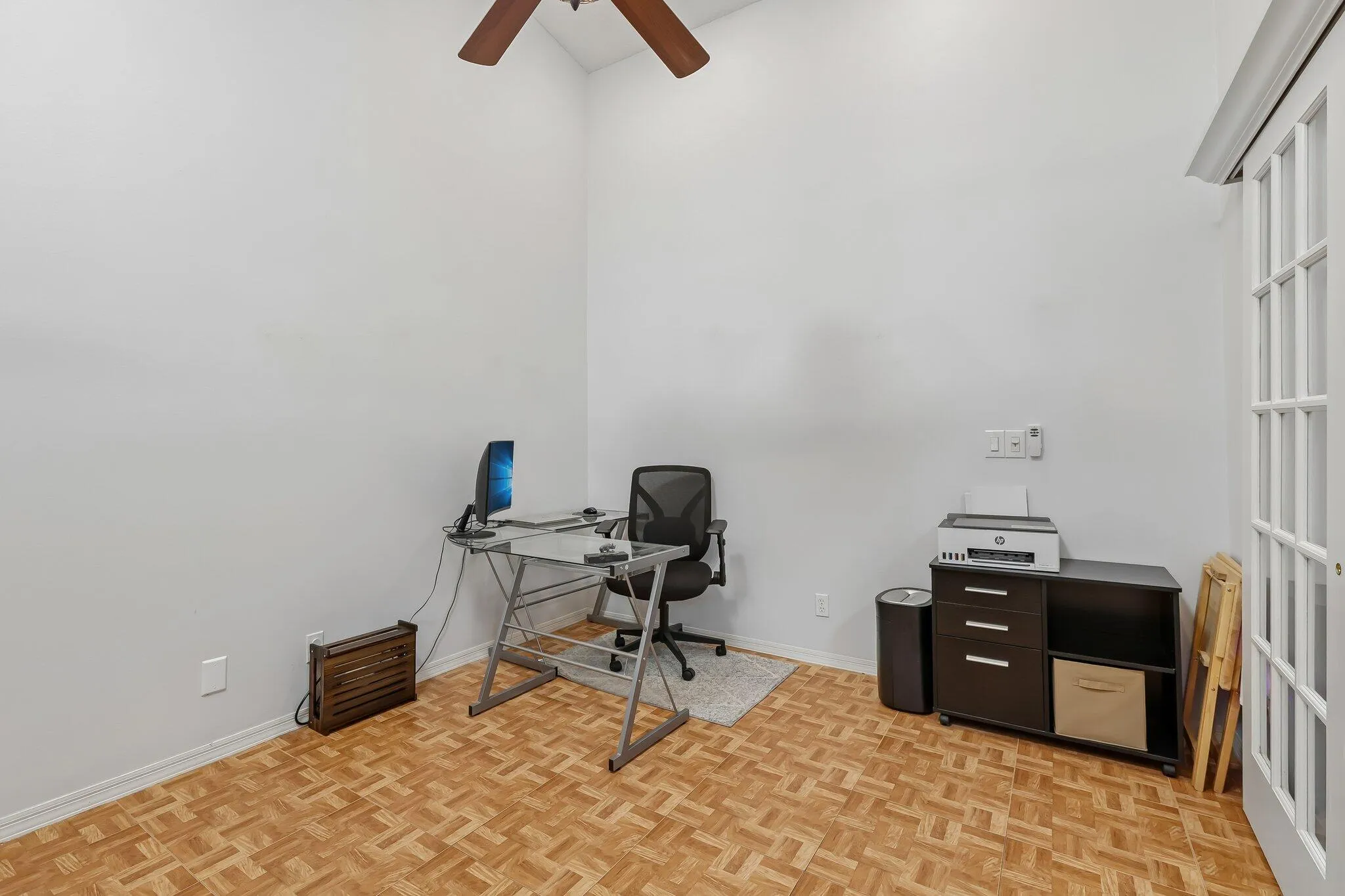 Vaulted ceiling, wood-finish flooring, ceiling fan, and French doors