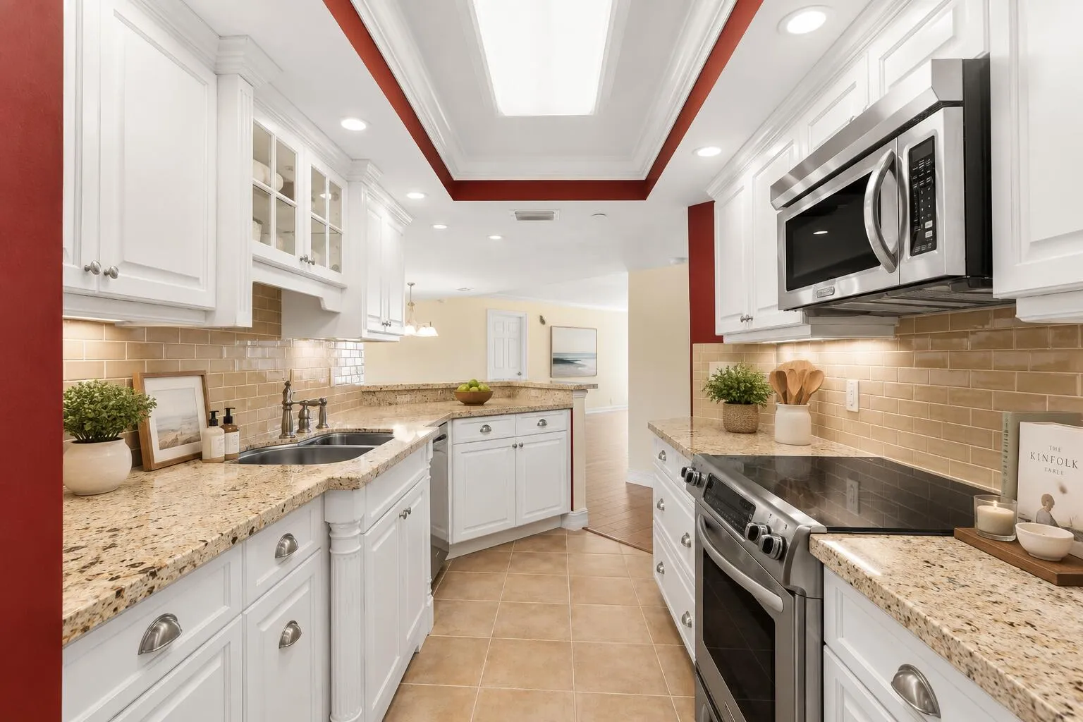 The kitchen combines granite countertops, white cabinetry, tiled backsplash and stainless-finish appliances with generous prep and storage space.