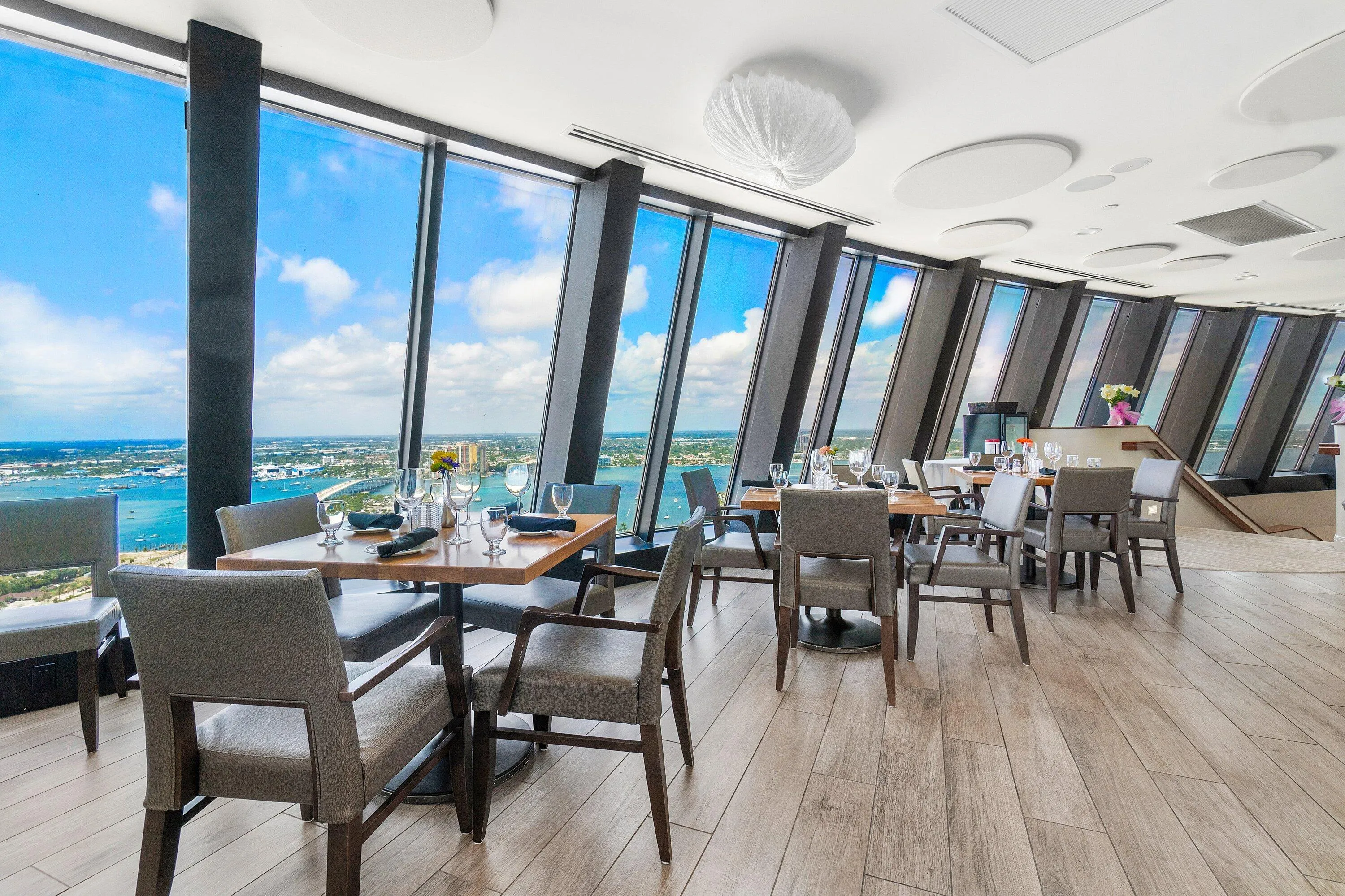 Dining tables line expansive windows overlooking the Atlantic Ocean in one of Tiara's restaurant spaces.