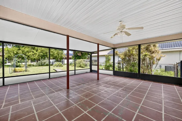 500+ SF of COVERED AND SCREENED LANAI with 2 pedestrian doors. Opens to Large fenced backyard.