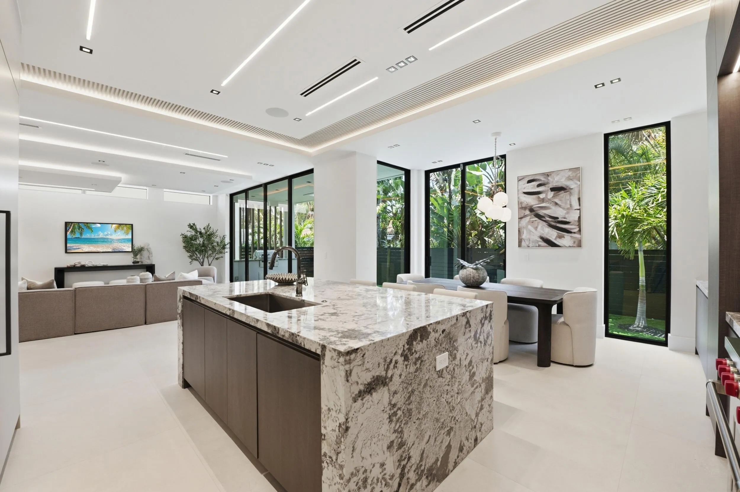 Waterfall island with integrated sink, full-height windows, recessed lighting, white tile flooring, and integrated ceiling vents