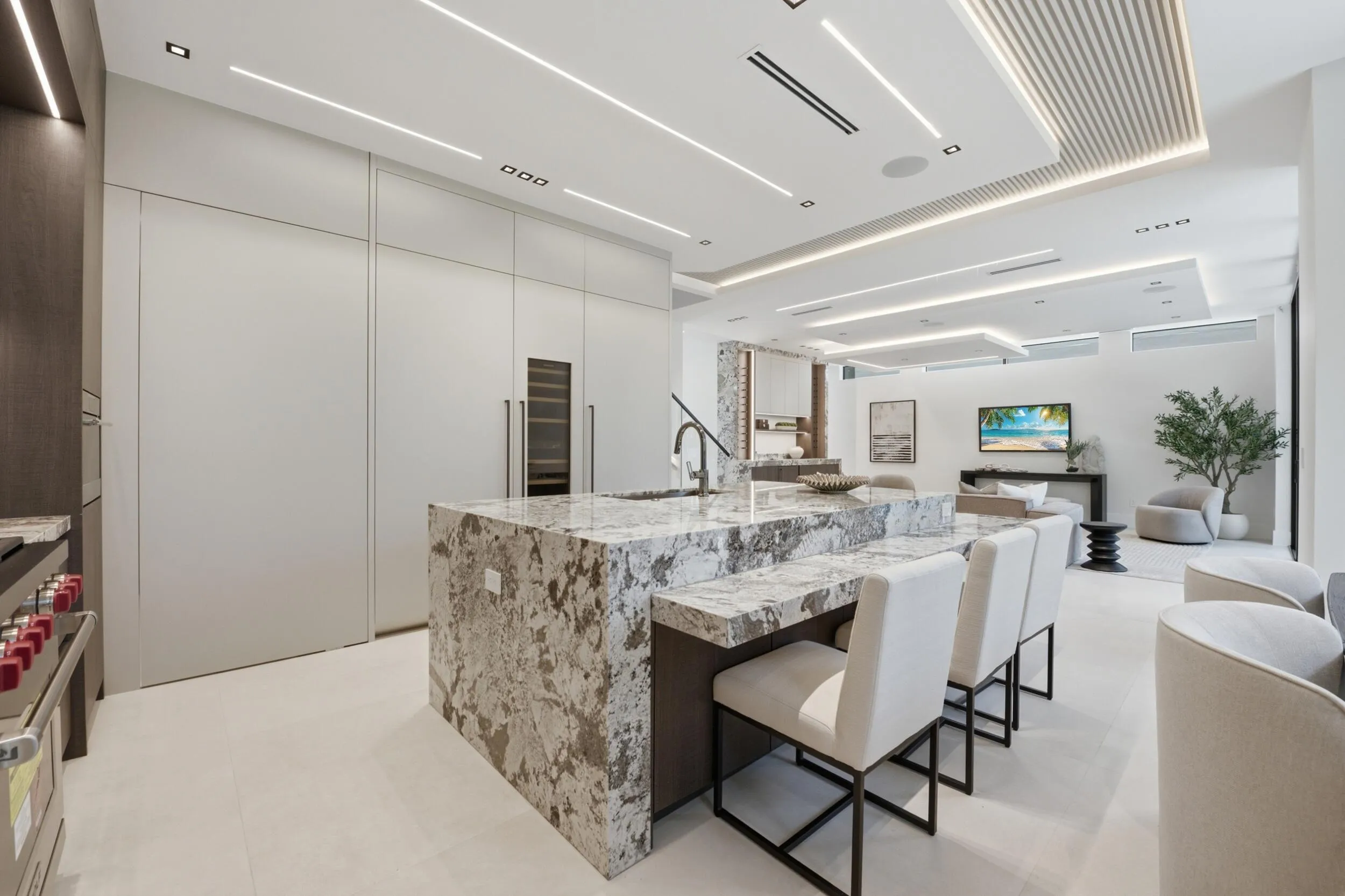 Kitchen island with a waterfall countertop, integrated wine refrigerator, built-in panel-ready appliances, and ceiling lighting