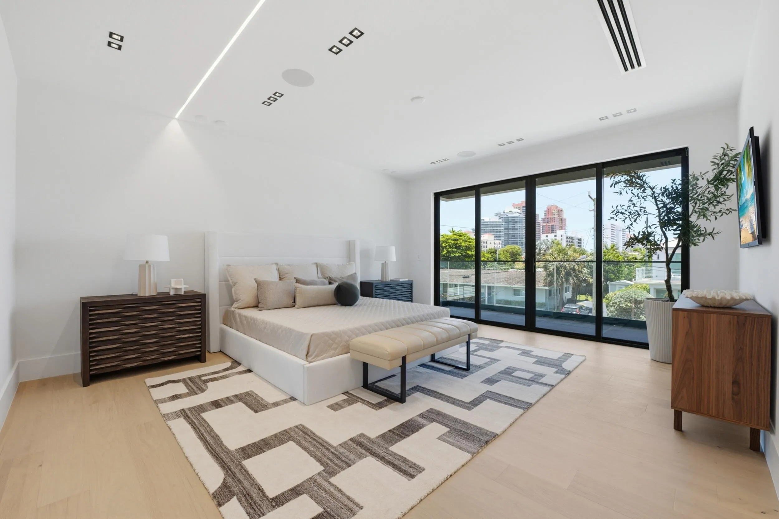 Expansive sliding glass doors, light wood-finish flooring, recessed lighting, and built-in ceiling speakers