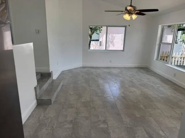 tiled living room with vaulted ceiling
