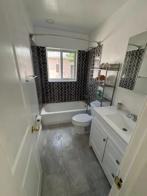 large tiled bathroom, with tub/shower