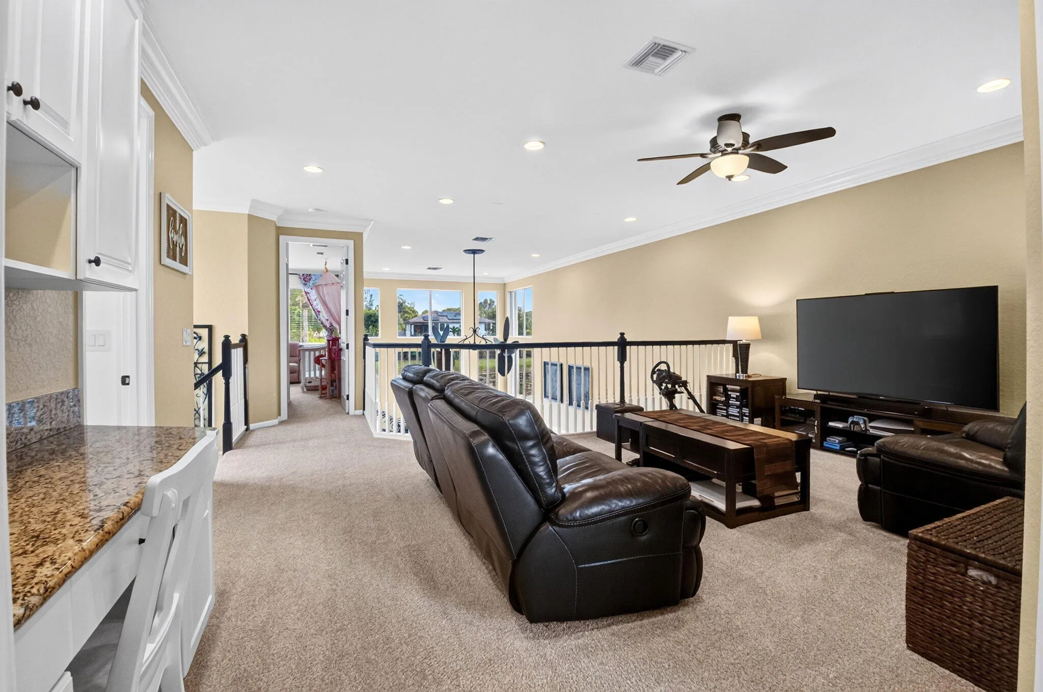 Open-concept living area with carpet flooring and warm-toned walls