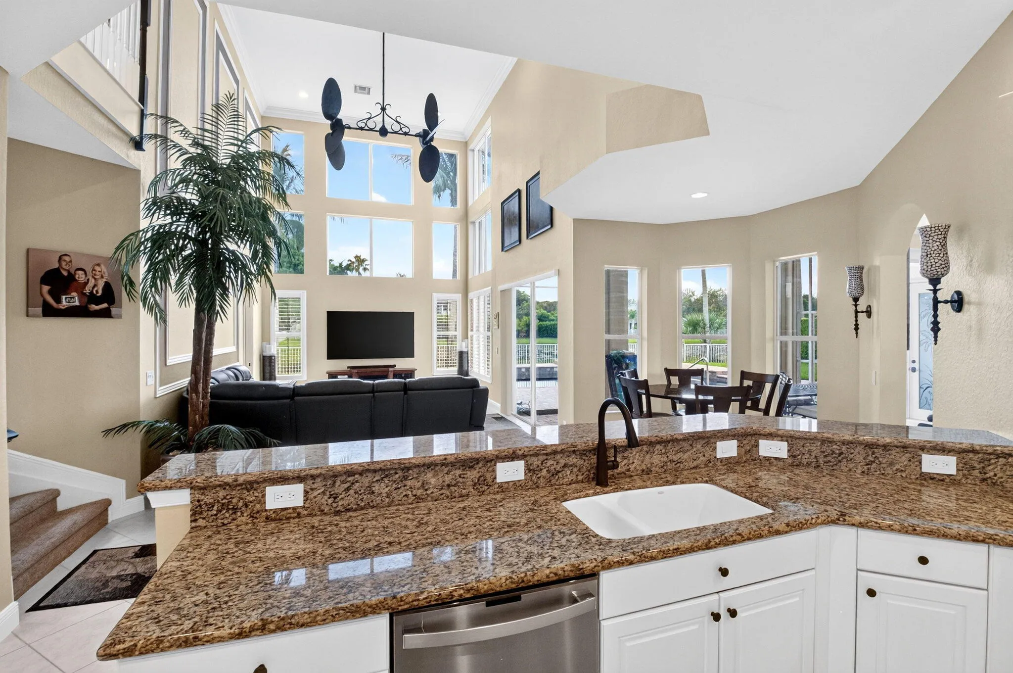 Kitchen island featuring a white undermount sink, gooseneck faucet, and integrated dishwasher