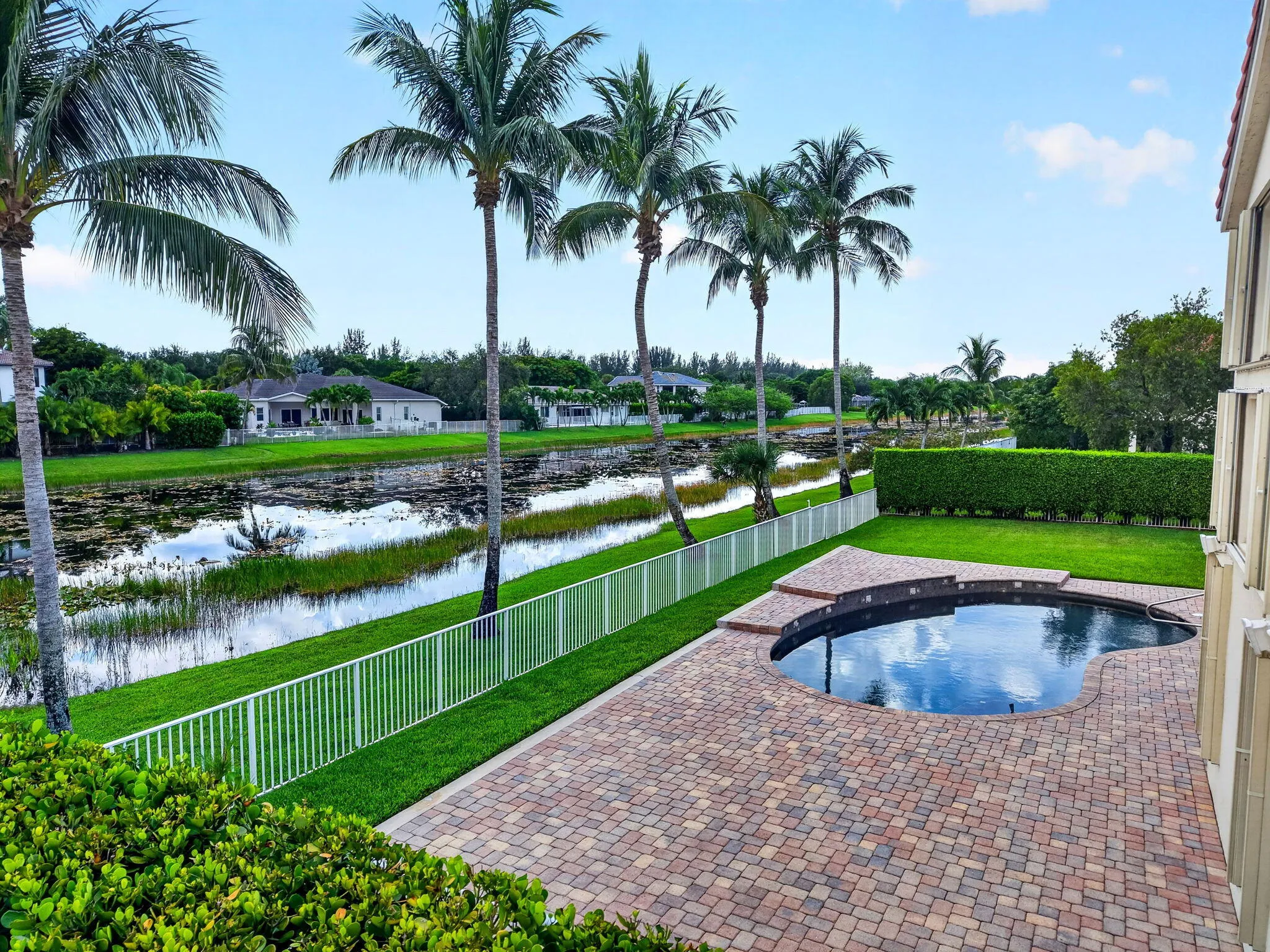 Freeform pool with paver decking, established lawn, and water feature