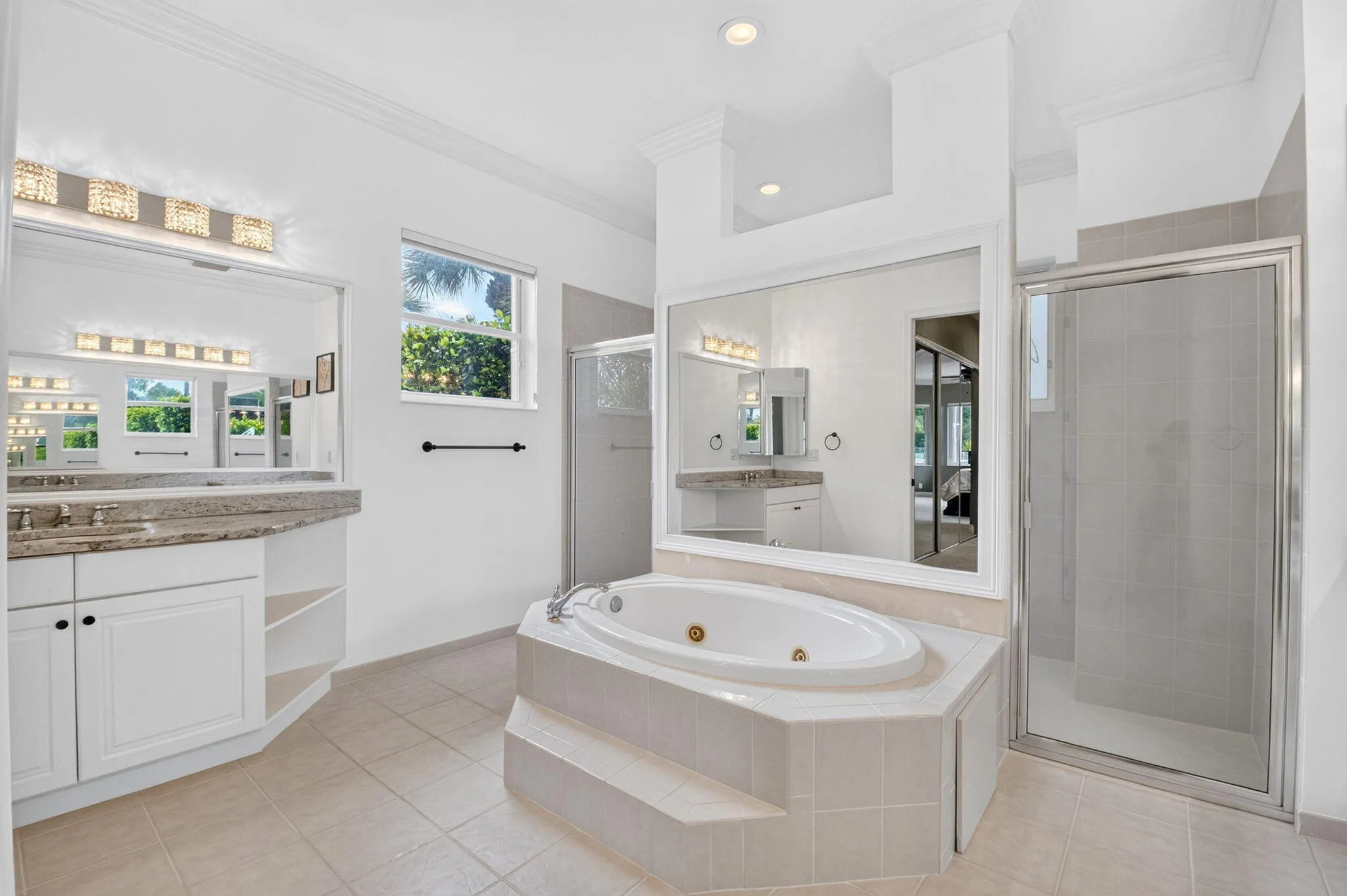 Dual vanity with granite-style countertop, white cabinetry, and undermount sinks