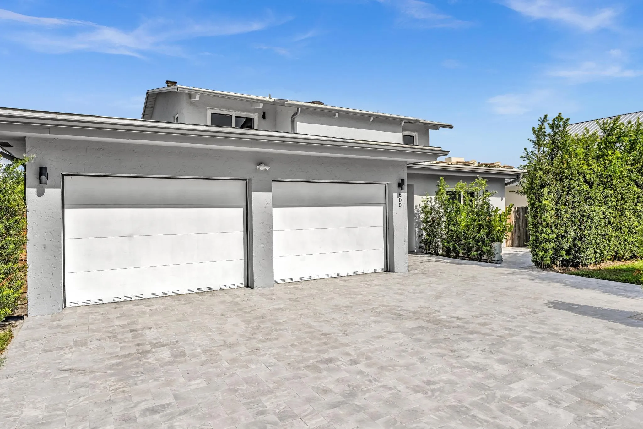 Front of Home with two car garage and paver driveway.