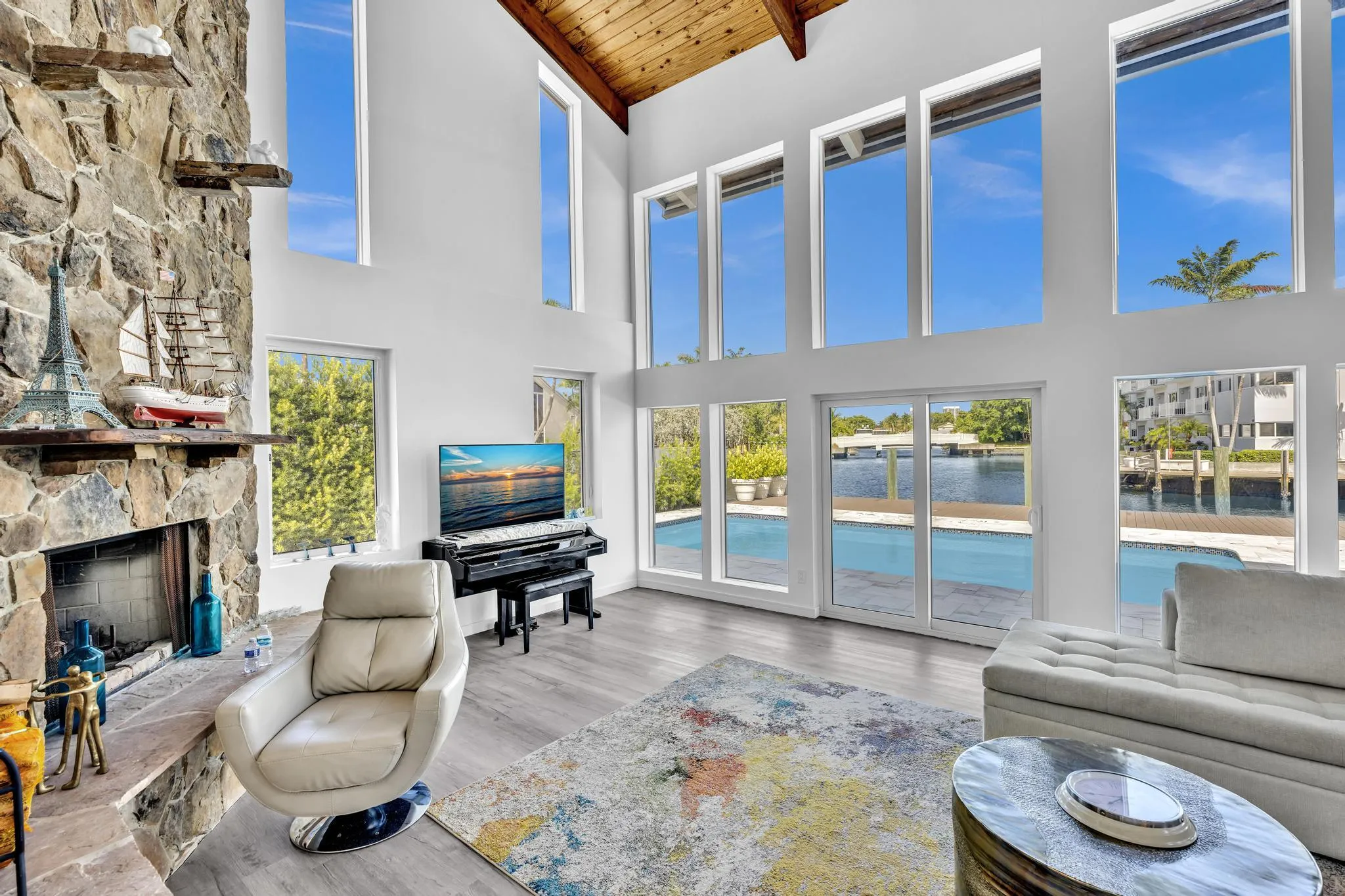 Vaulted ceiling living room with floor to ceiling windows.