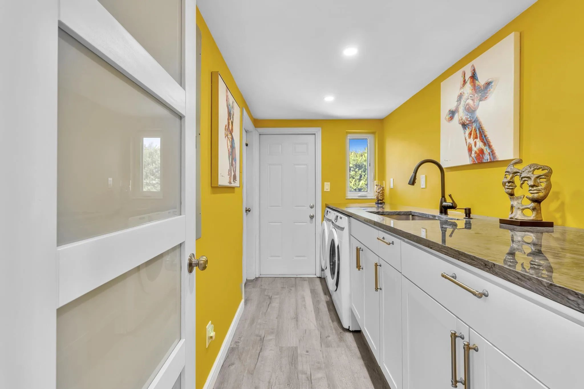 Laundry Room with washer and dryer, built in sink, and garage access.