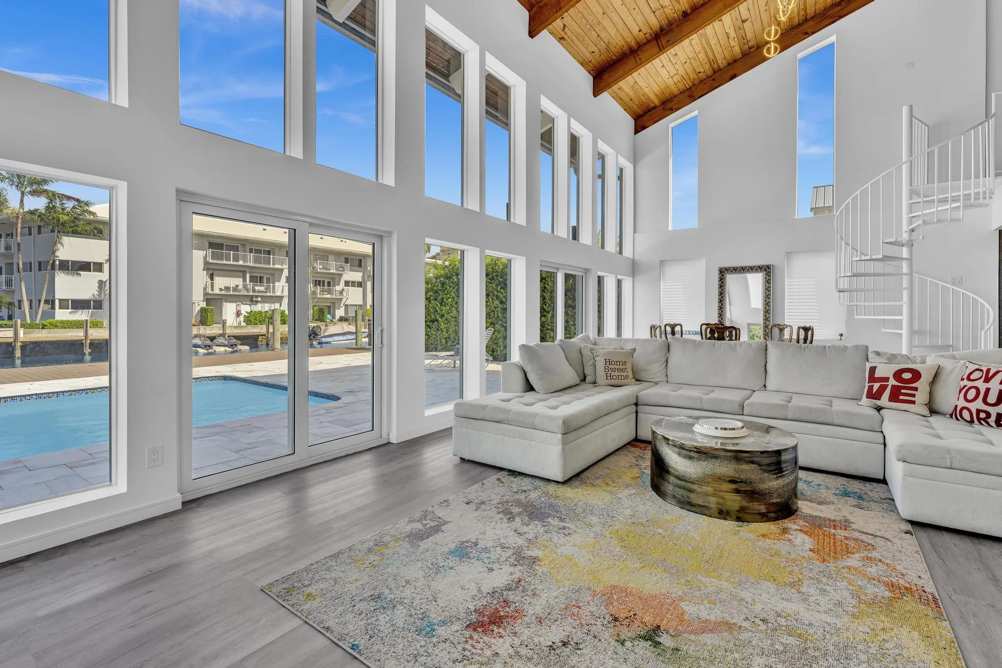 Vaulted ceiling living room with floor to ceiling windows.
