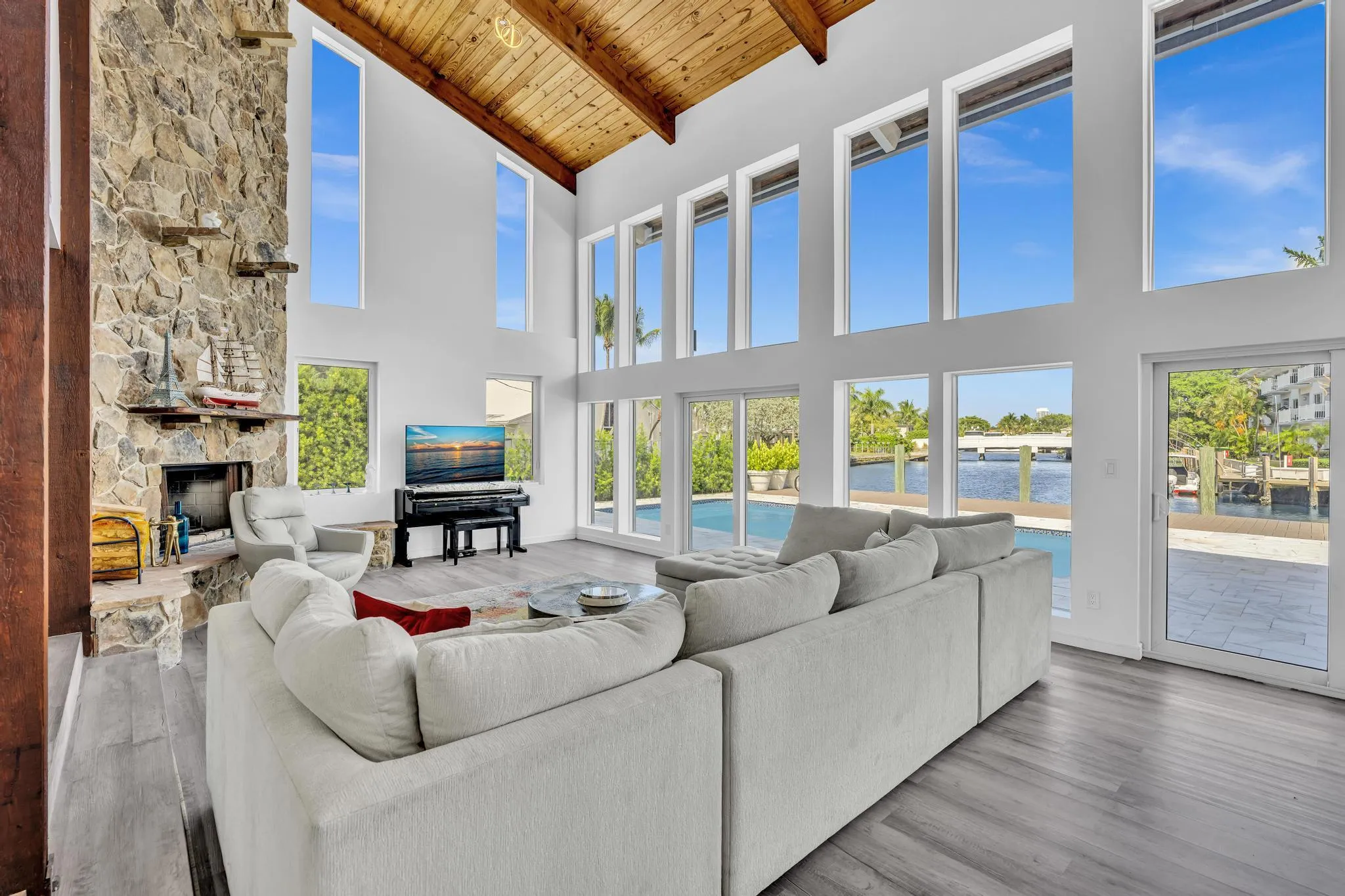 Vaulted ceiling living room with floor to ceiling windows.