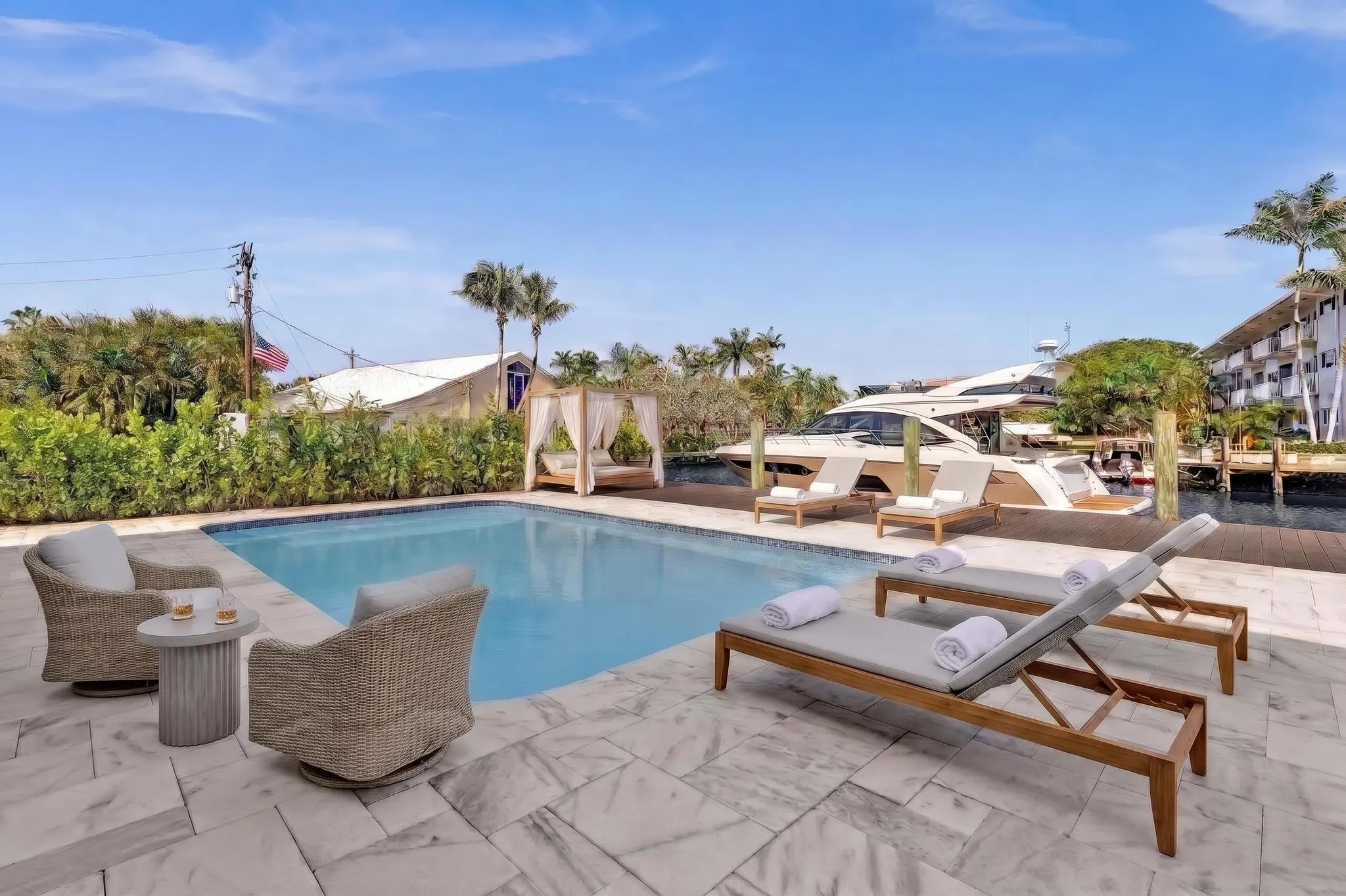 Back of home with lounge chaises and patio furniture. Virtually Staged