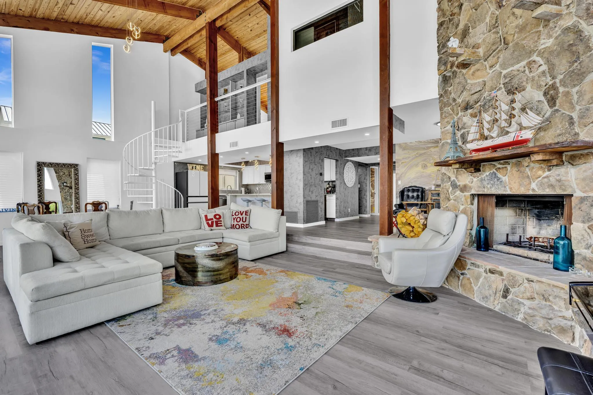 Vaulted ceiling living room with floor to ceiling windows.