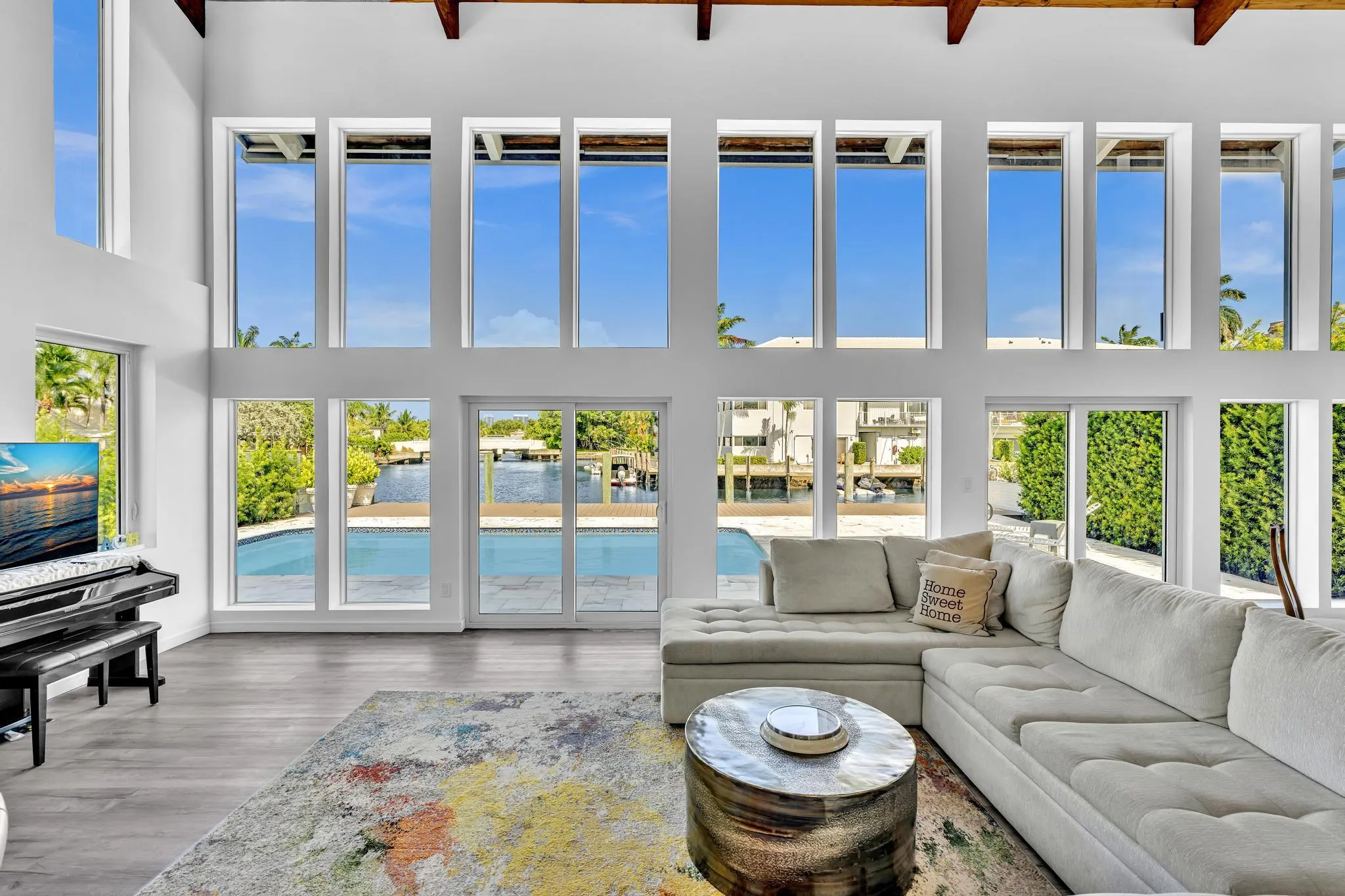Vaulted ceiling living room with floor to ceiling windows.