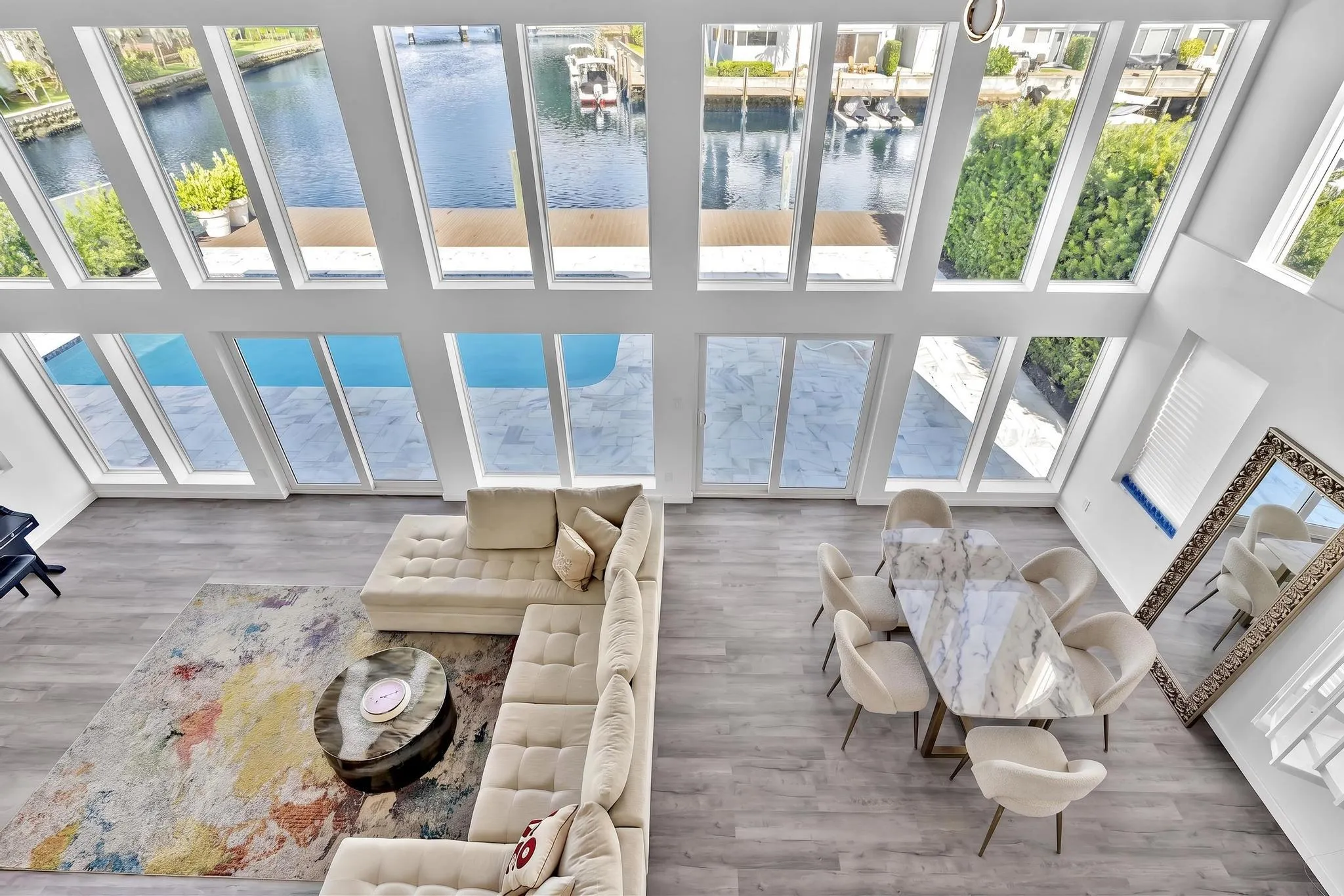 overview of living room with floor to ceiling windows. Virtually Staged