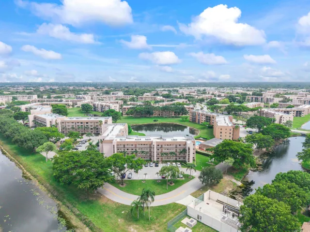 Expansive residential area featuring multiple residential buildings, lush green spaces, and a prominent water feature