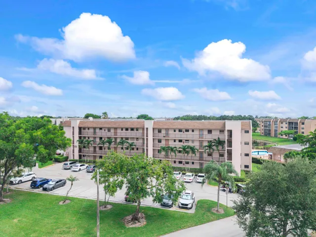 Multi-story residential building with private balconies and mature landscaping