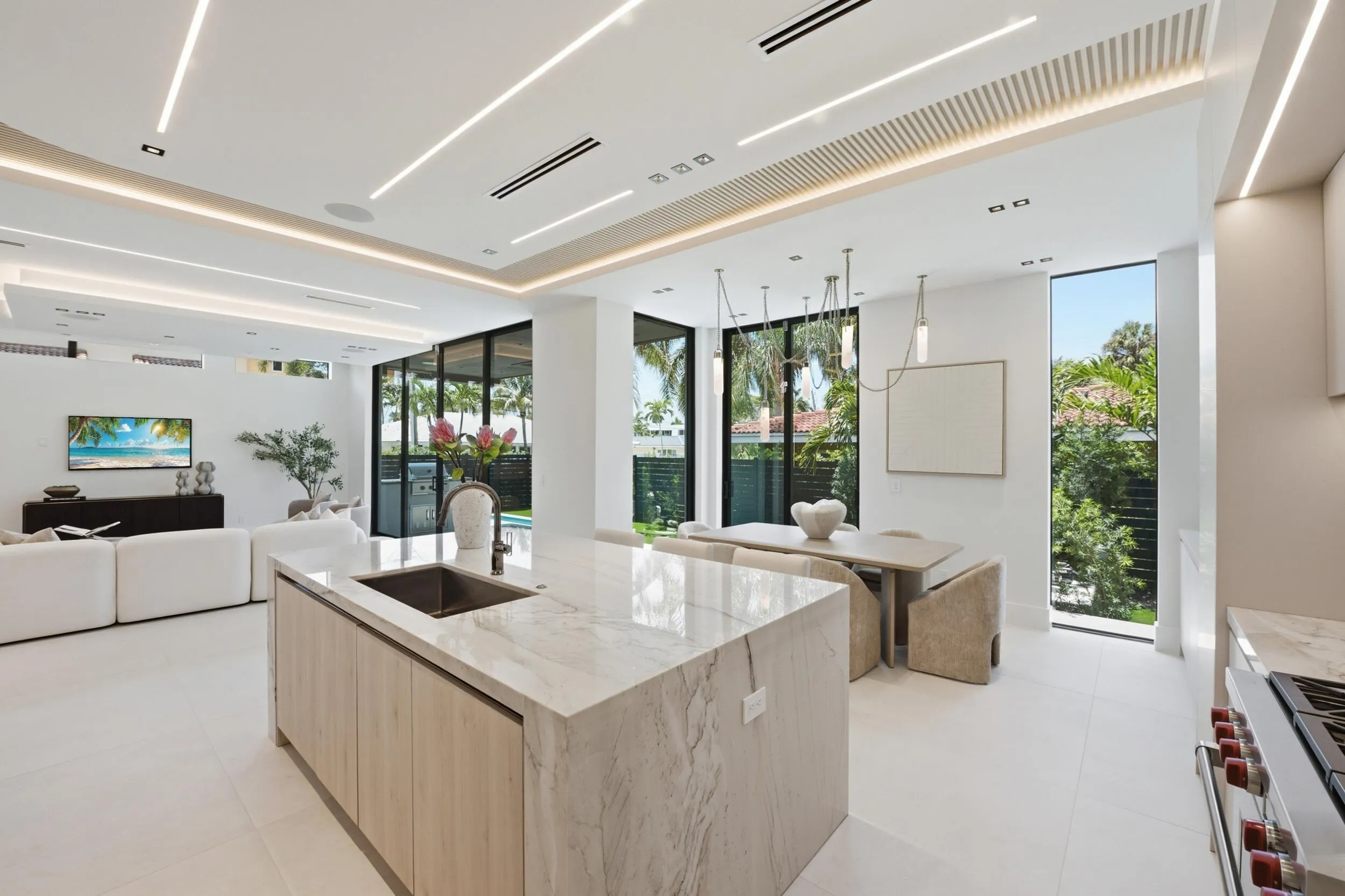 Gourmet kitchen with a waterfall island and integrated sink, complemented by recessed and cove lighting