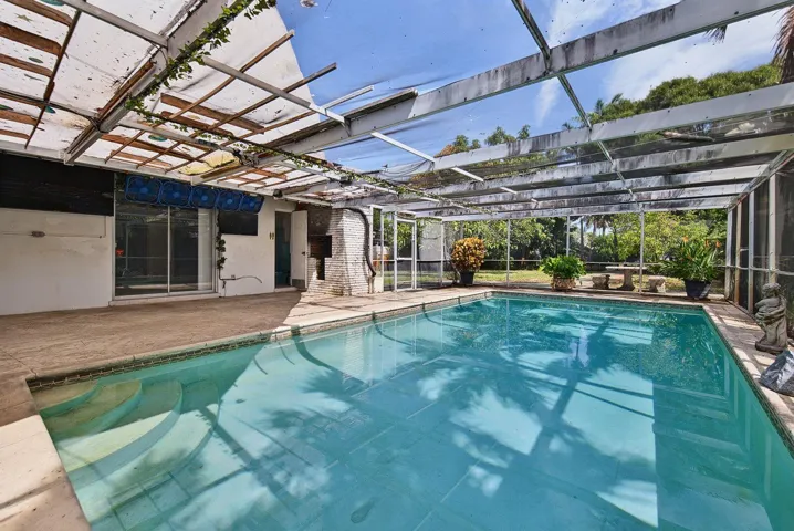 Screened pool area features generous deck space and a covered patio adjoining the residence.