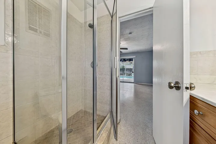 Detailed view of the tiled shower serving the adjoining bedroom suite.
