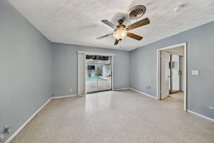 Comfortable bedroom with terrazzo flooring, an adjoining bathroom and direct access to the pool.