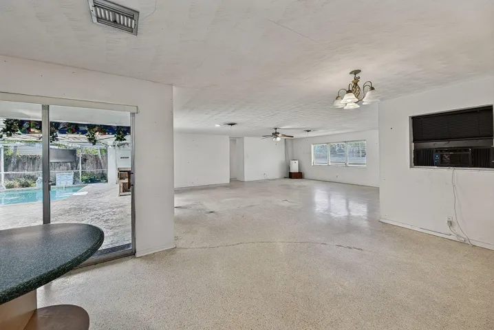 Broad interior view demonstrates the home’s spacious layout and connection to the pool area.