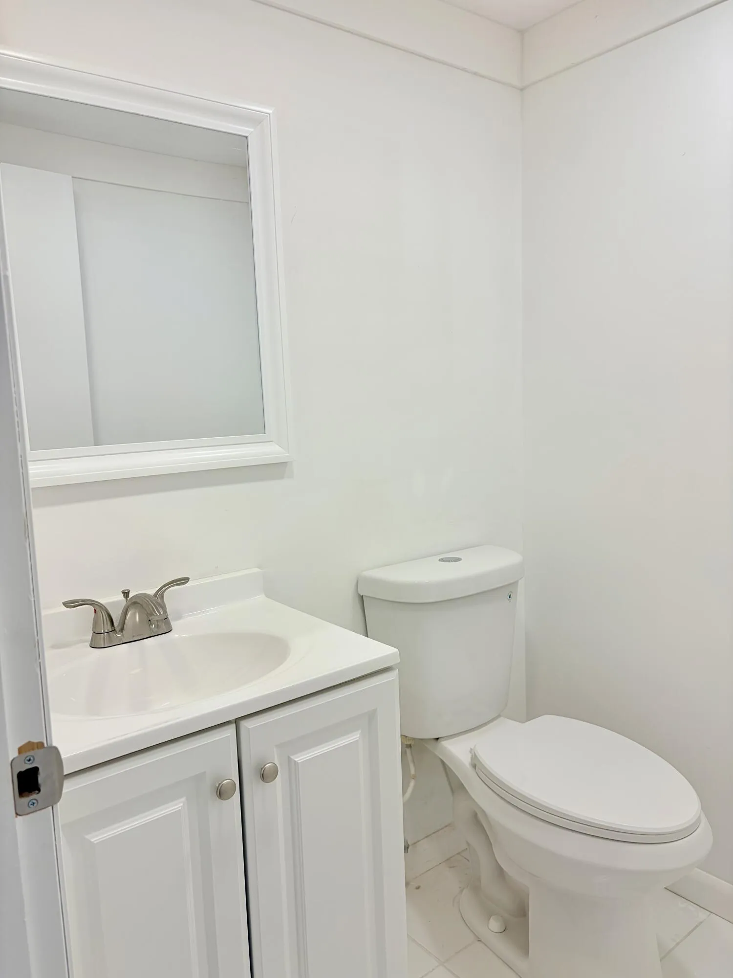 Vanity with integrated sink, white cabinetry, and brushed nickel hardware